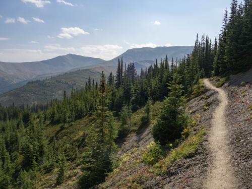 Mountains in the distance with a steep trail in the foreground