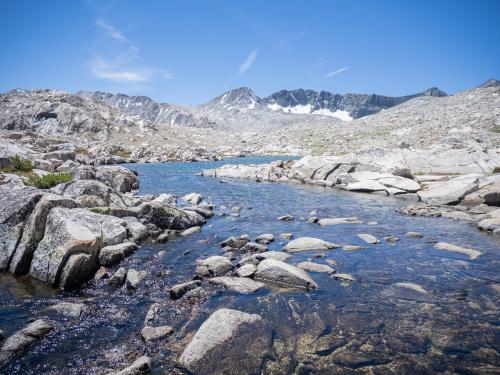 Alpine tarn and creek on granite shelf